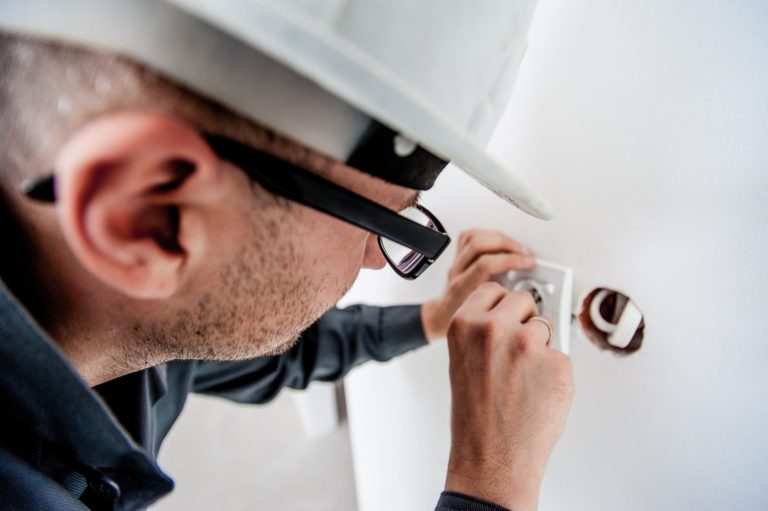 electrician fixing electrical issue in wall plug