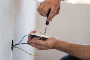 Electrician Changing Wiring Of An Outlet