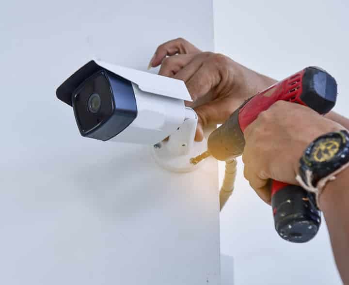 Technician installing CCTV camera for security - McGrath Electrical in South Grafton, NSW