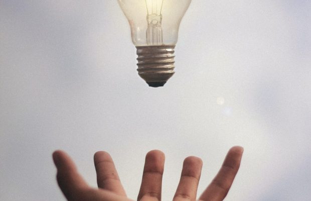 hand holding light bulb hand holding light bulb